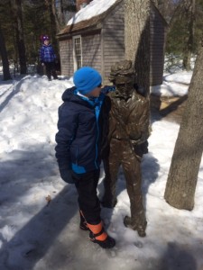 Kai meets a new friend, Henry David Thoreau.  Replica cabin in background.